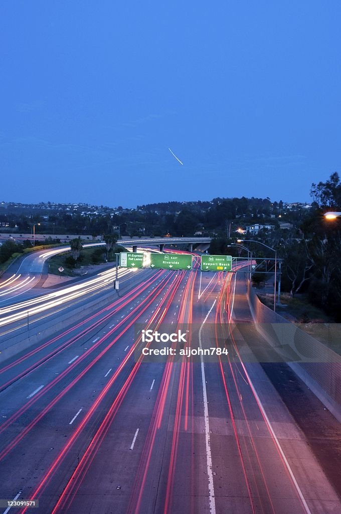 freeway lights Eastbound 91 freeway in Anaheim,CA at the 55 freeway interchange with an airplance streaking arcoss the sky. Anaheim - California Stock Photo
