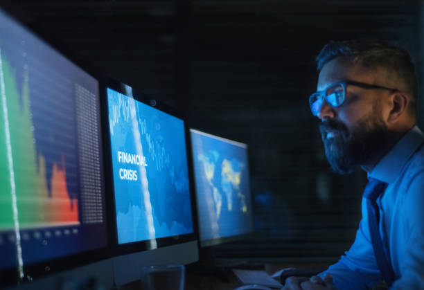 istock Businessman with computer sitting at desk, working late. Financial crisis concept. 1230916058