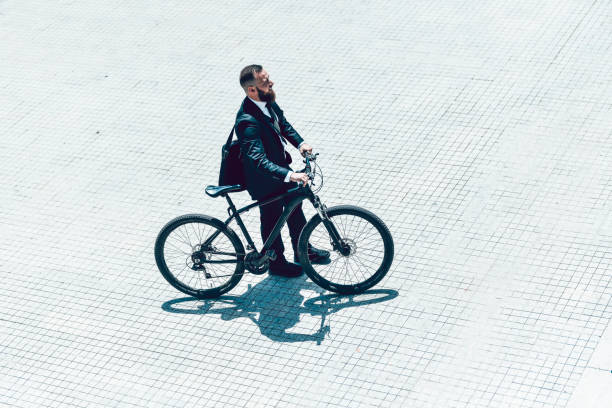 istock Businessman Enjoying Bicycle Ride On Town Square During Sunny Day 1230920493