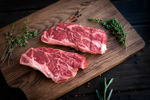 istock Raw chuck roll steaks premium beef with seasonings on wooden board, top view, rustic stule 1230927546