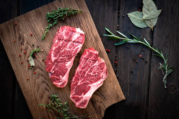 istock Raw chuck roll steaks premium beef with seasonings on wooden board, top view, rustic stule 1230929451