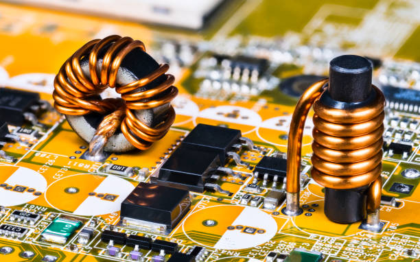 istock Toroidal and cylindrical inductor or coil on circuit board of computer mainboard detail 1230989062
