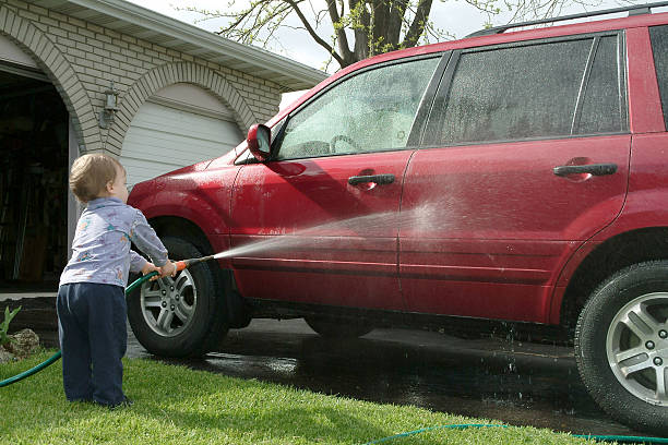 Siblings Teamwork Washing Family Car with Pressure Washer on a Sunny Day