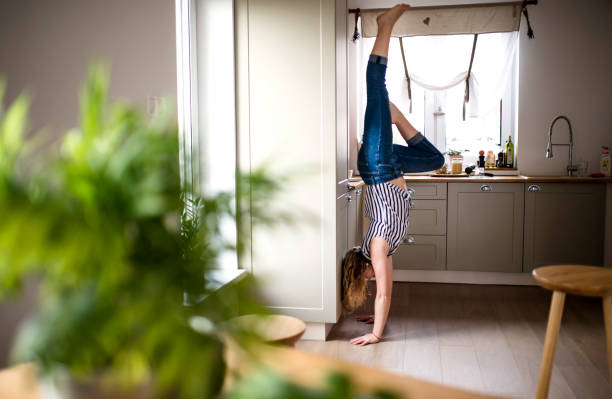 jovem praticando esporte dentro de casa, handstand. - parada de mãos - fotografias e filmes do acervo