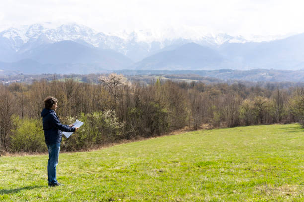 istock A man standing on a meadow with plans for his new house 1231018791