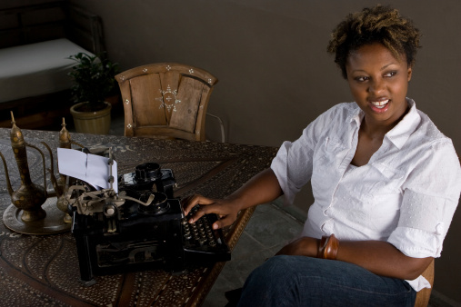 Beautiful African American woman with an old fashion typewriter
