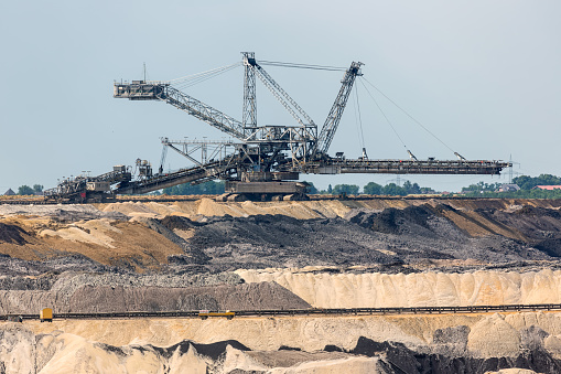 Brown coal open pit landscape with digging machine in Germany