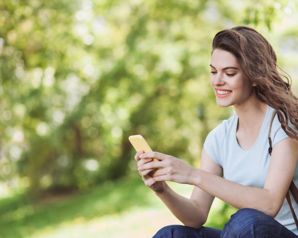 istock Beautiful young woman using smart phone in a city 1231067402
