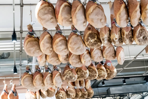 肉屋にぶら下がっているイタリアの生ハム - meat butchers shop raw market ストックフォトと画像
