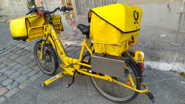 deutsche post gelbes fahrrad - messenger deutsche post ag package germany stock-fotos und bilder