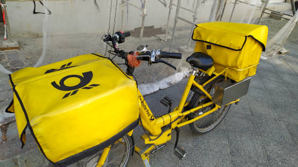 deutsche post gelbes fahrrad - messenger deutsche post ag package germany stock-fotos und bilder