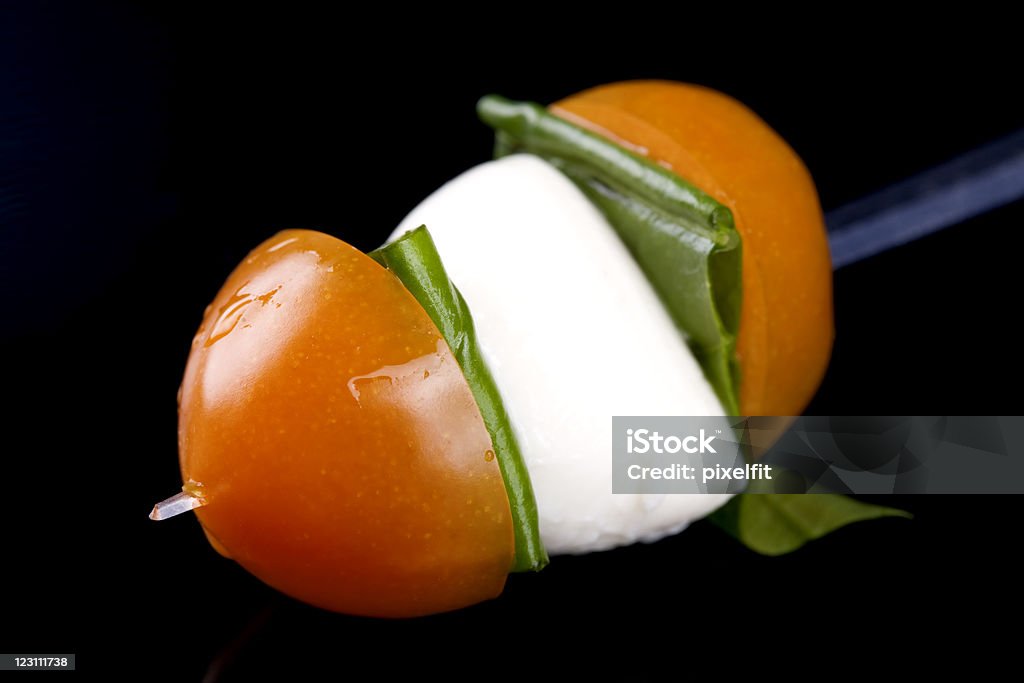 Caprese skewer on black pad Cherry tomato with Mozzarella and fresh Basil. Appetizer Stock Photo
