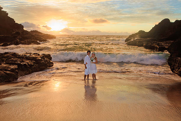 young mixed newlywed couple at sunrise on Eternity Beach, Hawaii