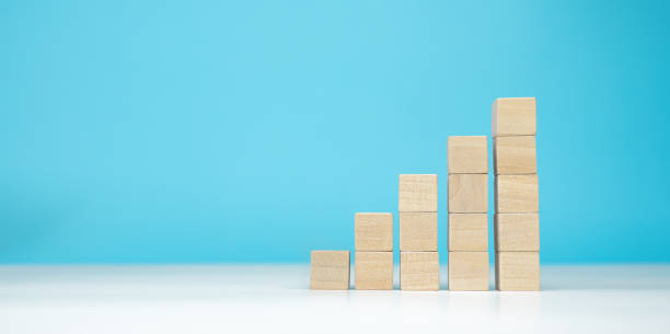 istock wooden blocks as a pyramid staircase on blue background. Success, growth, win, victory, development or top ranking concept 1231164037
