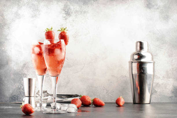 Rossini italian red alcoholic cocktail with sparkling wine, strawberry puree and ice in champagne glasses, copy space