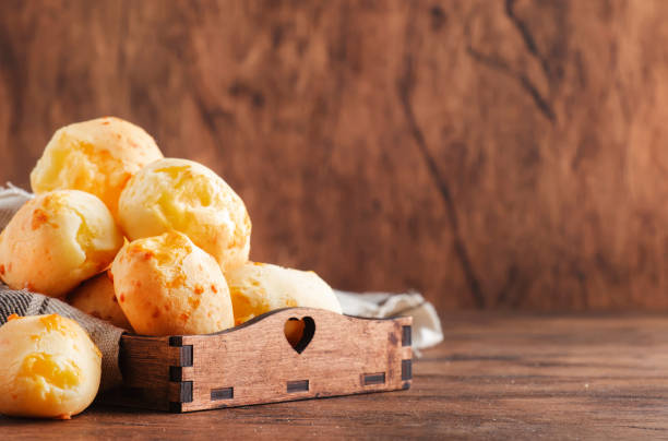 istock Golden Cheese buns in wooden tray, rustic kitchen table, copy space 1231226598