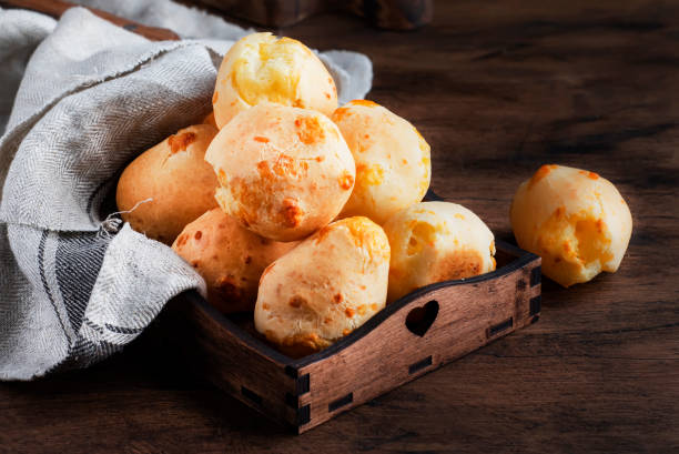 istock Golden Cheese buns in wooden tray, rustic kitchen table, copy space 1231228636