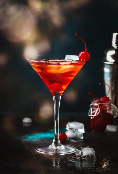 манхэттенский алкогольный коктейль с бурбоном, красным вермутом, горьким, ледяным и коктейльным вишней в стекле, изображением ночного наст - manhattan cocktail cocktail drink cherry стоковые фото и изображения
