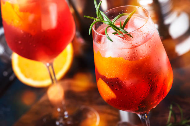 milano spritzer cocktail alcolico italiano con vino rosso amaro, bianco secco, soda, scorza e ghiaccio. sfondo blu, utensili a barre in acciaio, spazio di copia - glass bar relaxation red foto e immagini stock