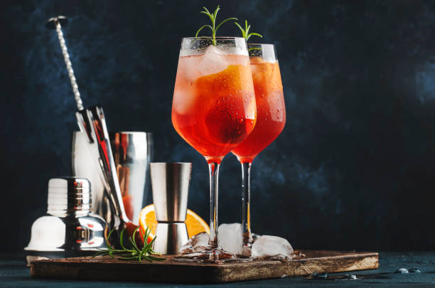 milano spritzer cocktail alcolico italiano con vino rosso amaro, bianco secco, soda, scorza e ghiaccio. sfondo blu, utensili a barre in acciaio, spazio di copia - glass bar relaxation red foto e immagini stock