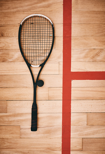 Shot of a squash racquet on the floor of a squash court