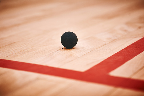 Shot of a squash ball on the floor of a squash court