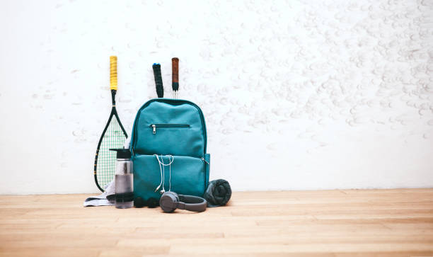 Gear fit for a pro Shot of a sports bag and other items in an empty squash court tennis ball container stock pictures, royalty-free photos & images