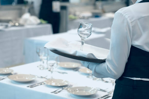istock Waitress dressed in the uniform serving a set of glasses 1231329404