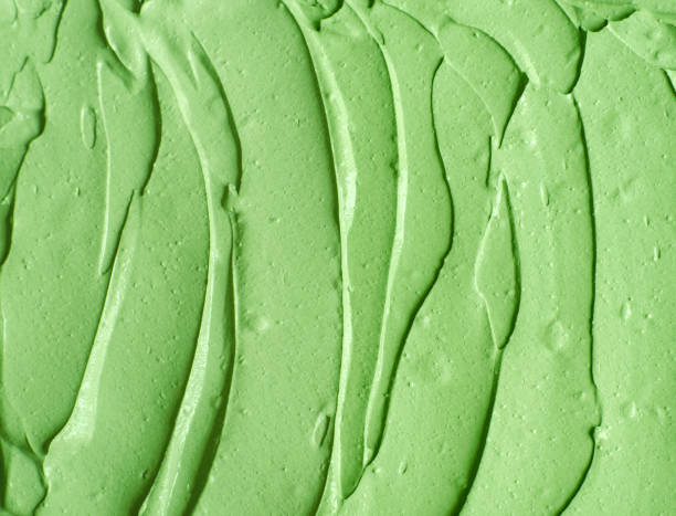 istock Green cosmetic clay (cucumber facial mask, avocado face cream, green tea matcha body wrap) texture close up, selective focus. Abstract background with brush strokes. 1231335985