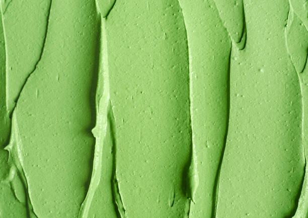 istock Green cosmetic clay (cucumber facial mask, avocado face cream, green tea matcha body wrap) texture close up, selective focus. Abstract background with brush strokes. 1231337614