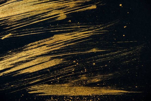 istock strokes with golden paint brush on black paper. 1231349381