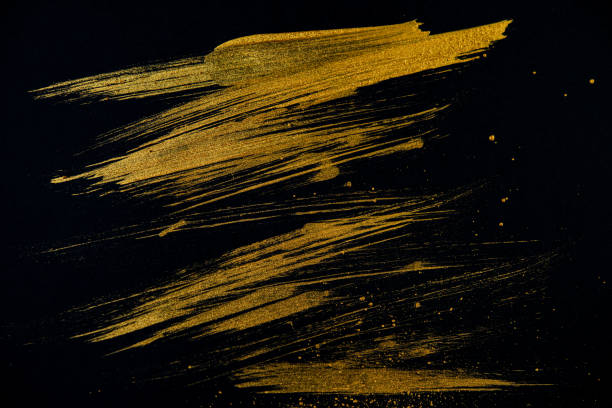 istock strokes with golden paint brush on black paper. 1231350589