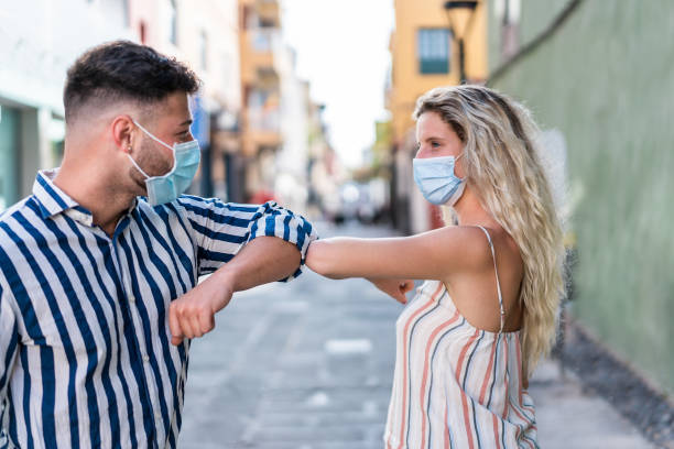 istock Young people bump their elbows instead of greeting with a hug - Avoid the spread of coronavirus concept - Focus on elbows 1231368593