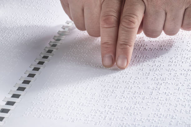 istock Hand of a blind person reading some braille text touching the relief. Empty copy space for Editor Horizontal 1231371704