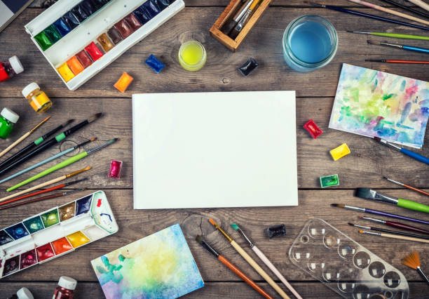 Blank artist canvas and art accessories. Blank artist canvas and art accessories. Set of painter accessories. Watercolor aquarelle paints, art brushes, palette, glass of water on old wooden background. coloring photos stock pictures, royalty-free photos & images
