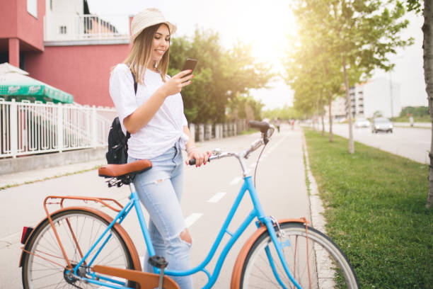 istock Attractive young woman using her cellphone while cycling through the city 1231412251