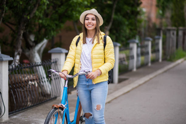 istock Pretty young woman walking and pushing her bicycle. 1231423477
