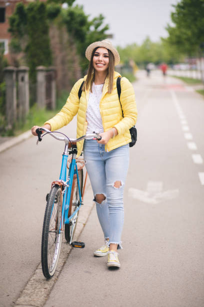 istock Pretty young woman walking and pushing her bicycle. 1231424499