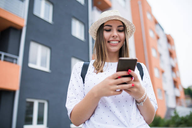 istock Young pretty woman text messaging through smart phone. 1231426551