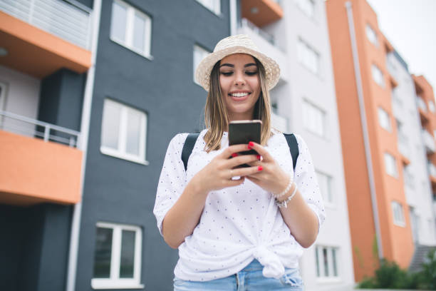 istock Young pretty woman text messaging through smart phone. 1231427586