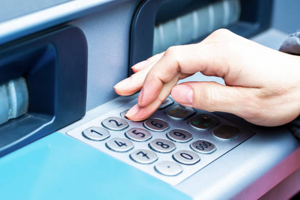istock Close up of female hand entering PIN pass code on ATM bank machine keypad 1231452617