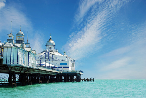 Brighton seaside resort beach and Brighton Palace Pier in a summer sunny blue sky day with tourists in UK, Great Britain, England in East Sussex 47 miles south London, called as \