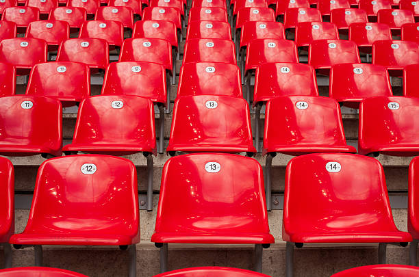 Rows and rows of red stadium seats stock photo