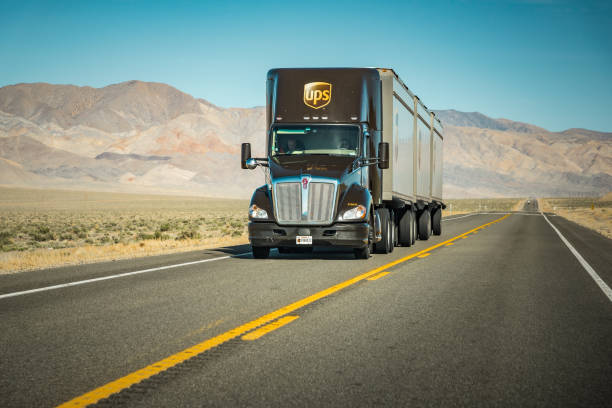 ups (united parcel service) camion sur l’interstate solitaire dans l’ouest américain - united parcel service truck shipping delivering photos et images de collection