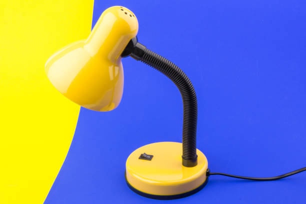 istock Yellow desk lamp isolated on blue and yellow background 1231478291