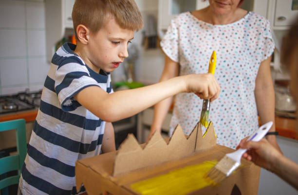 istock Brothers painting a cardboard dinosaur costume 1231481753