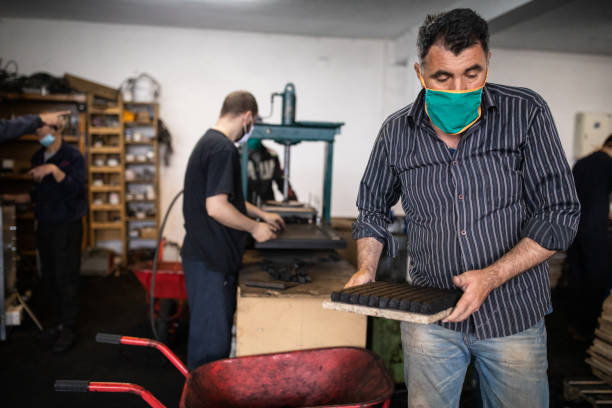 istock Manual workers in factory manufacturing coconut charcoal for hookah 1231489122