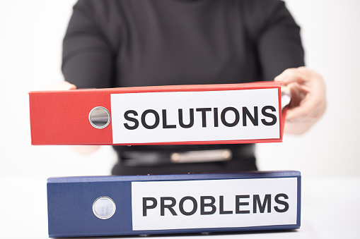 Problems and Solutions - two binders with text on desk in the office White background