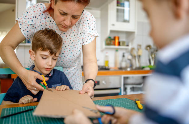 istock Mom and kids making a cardboard dinosaur costume 1231494331