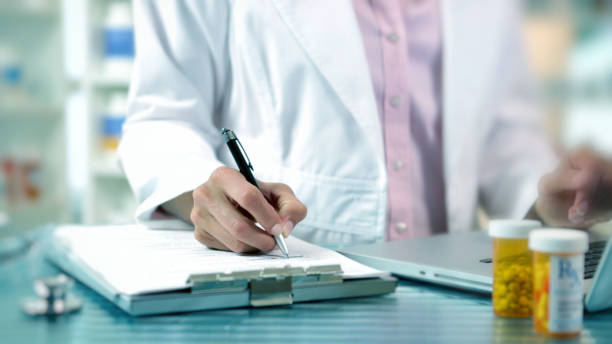 woman writing notes at pharmacy. - prescription doctor rx pharmacist imagens e fotografias de stock